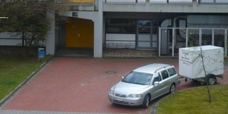 The image shows the arrival of Nobert Kockmann in a car with trailer in front of the G3 building.