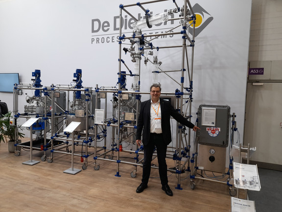 The image shows Prof. Kockmann in front of the apparatus of De Dietrich.