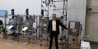 The image shows Prof. Kockmann in front of the apparatus of De Dietrich.